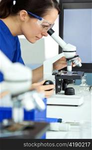 Female Scientist or Woman Researcher Using Microscope in Laboratory