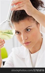 Female Scientist Studying Liquid In Flask