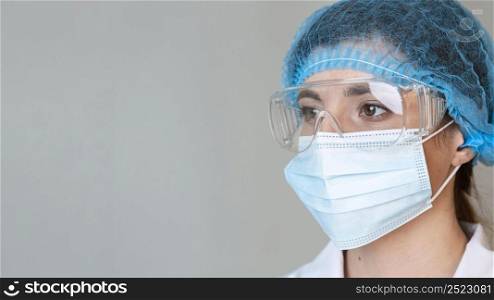 female scientist with safety glasses hair net medical mask