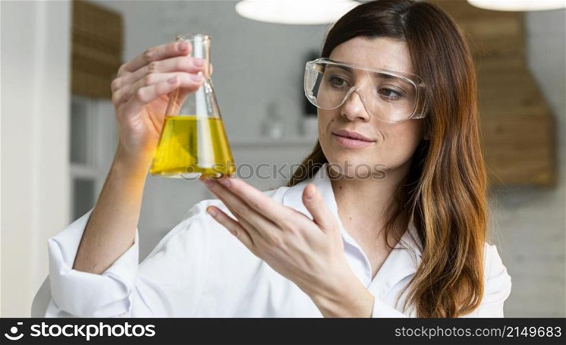 female scientist with safety glasses holding test tube