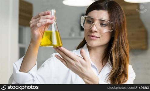 female scientist with safety glasses holding test tube
