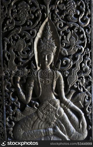 Female sculpture carved on door of temple, Luang Prabang, Laos
