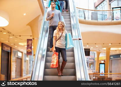 Female Shopper On Escalator In Shopping Mall