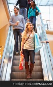 Female Shopper On Escalator In Shopping Mall