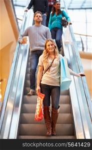 Female Shopper On Escalator In Shopping Mall