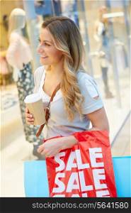 Female Shopper With Takeaway Coffee In Mall