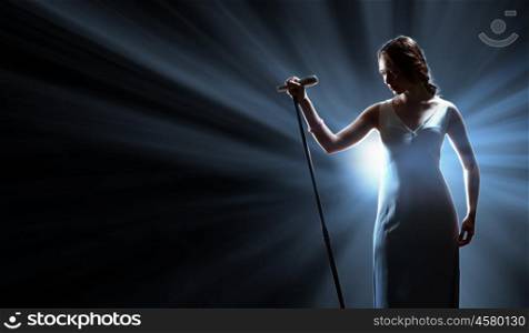 Female singer on the stage holding a microphone. Female singer on the stage