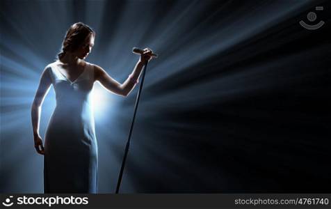 Female singer on the stage holding a microphone. Female singer on the stage