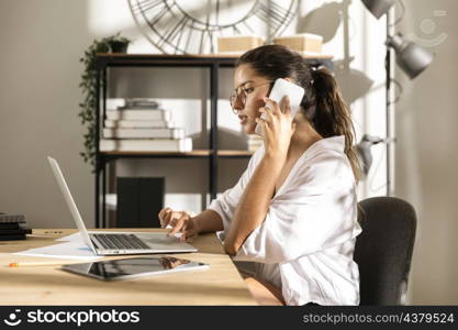 female sitting table talking phone
