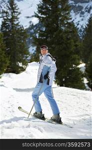 Female skier standing on ski slope