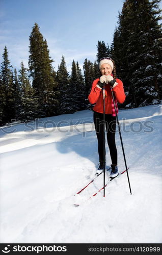 Female Snow Skiier Leaning on Poles and Smiling