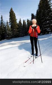 Female Snow Skiier Leaning on Poles and Smiling