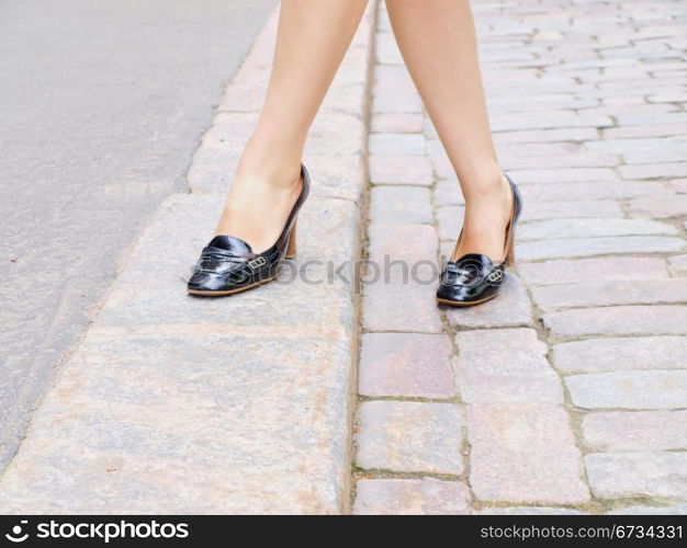 Female stepping onto the sidewalk in a street