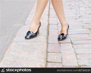 Female stepping onto the sidewalk in a street