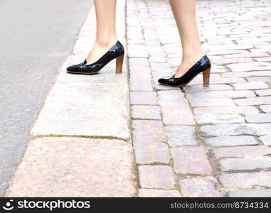 Female stepping onto the sidewalk in a street