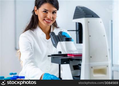Female Student in Laboratory, Placing Culture Flask on the Microscope Observation Stage