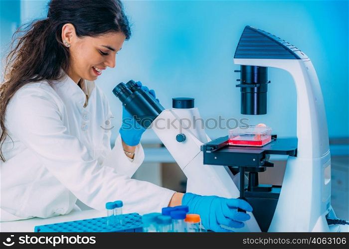 Female Student in Laboratory, Placing Culture Flask on the Microscope Observation Stage