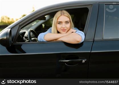 Female student poses in car, lesson in driving school. Man teaching lady to drive vehicle. Driver&rsquo;s license education. Female student poses in car, driving school