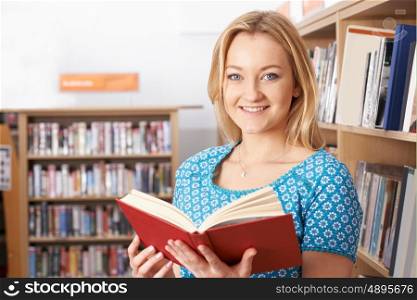 Female Student Reading Book In Library