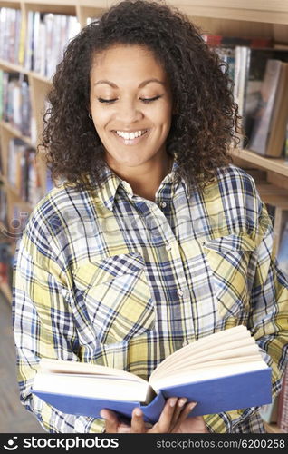 Female Student Reading Book In Library