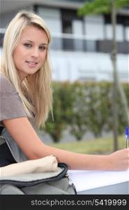 Female student sat outdoors studying