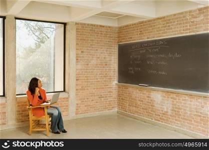 Female student sat working alone
