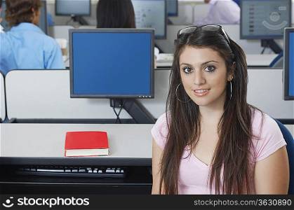 Female student sitting in computer classroom, portrait