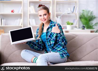 Female student sitting on the sofa with laptop