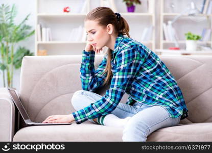 Female student sitting on the sofa with laptop