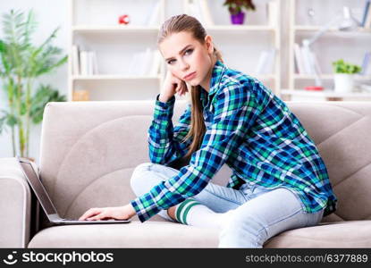 Female student sitting on the sofa with laptop