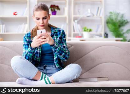 Female student sitting on the sofa with mobile