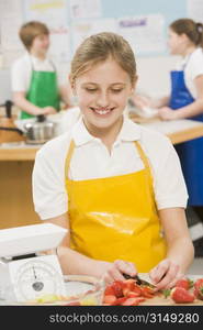 Female student slicing berries in cooking class