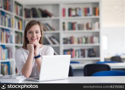 female student study in library using laptop and searching for informations on internet
