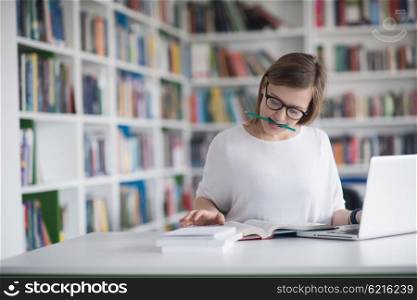 female student study in library using laptop and searching for informations on internet