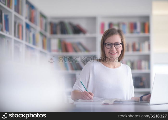 female student study in library using laptop and searching for informations on internet