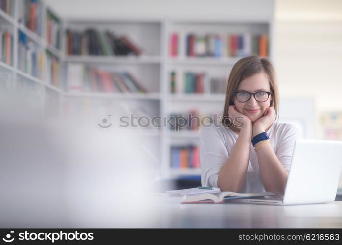 female student study in library using laptop and searching for informations on internet