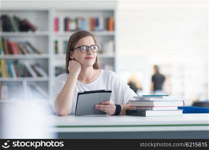female student study in library using tablet and searching for informations on internet
