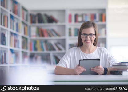 female student study in library using tablet and searching for informations on internet