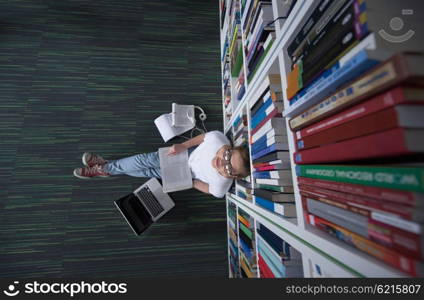 female student study in library using tablet and searching internet while Listening music and lessons on white headphones