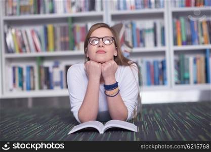 female student study in school library, using tablet and searching for information?s on internet. Listening music and lessons on white headphones