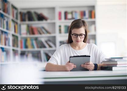 female student study in school library, using tablet and searching for informations on internet