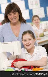 Female student using sewing machine with teacher