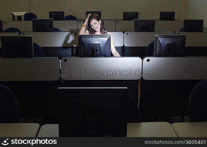 Female student with hand on head in computer classroom