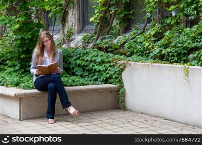 Female student with her journal sits outside