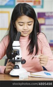 Female Student With Microscope In Science Class