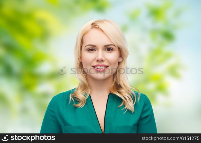 female, summer, portrait and people concept - smiling young woman face over green natural background