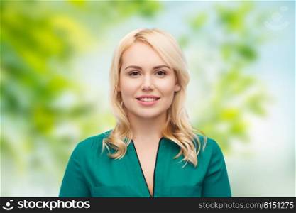 female, summer, portrait and people concept - smiling young woman face over green natural background