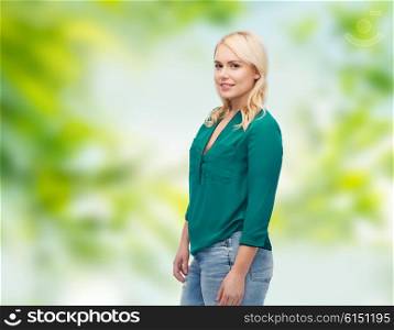 female, summer, portrait, plus size and people concept - smiling young woman in shirt and jeans over green natural background