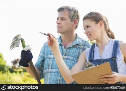 Female supervisor explaining something to gardener at plant nursery