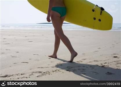 Female surfer carrying a surfboard